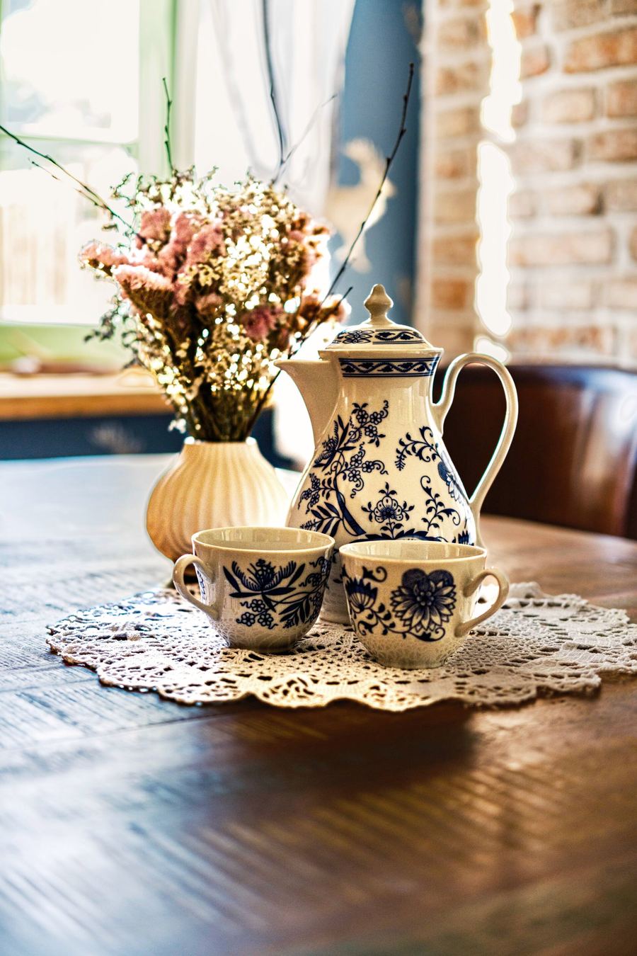 Modrobílá porcelánová konvice a šálky na krajkové dečce